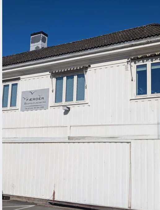 Færder Begravelsesbyrå sitt hovedkontor i Tønsberg, hvit fasade mot blå himmel